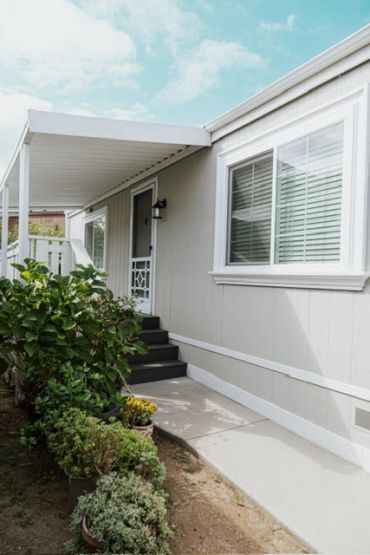 Entrance to a mobile home with plants and stairs.