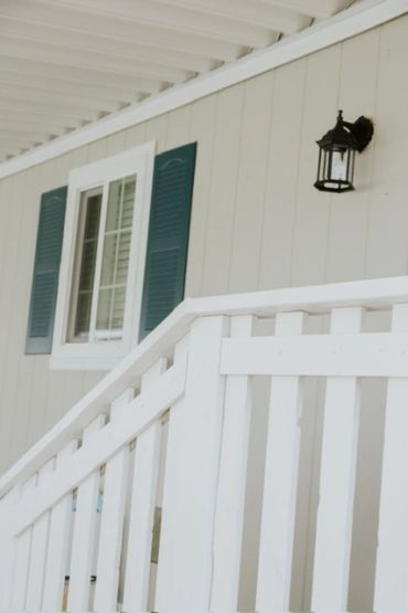 White porch railing with a window and outdoor light.