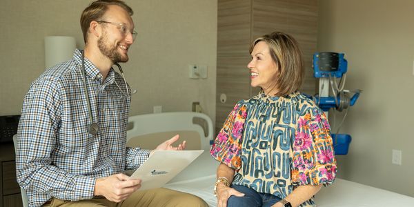 Doctor and patient having a friendly consultation in a medical office.
