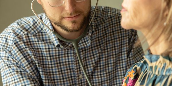 A doctor uses a stethoscope to listen to a patient's chest.