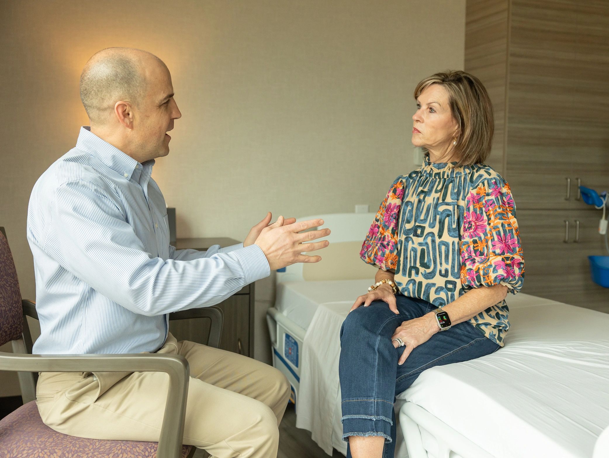 Man and woman having a serious conversation in a hospital room.