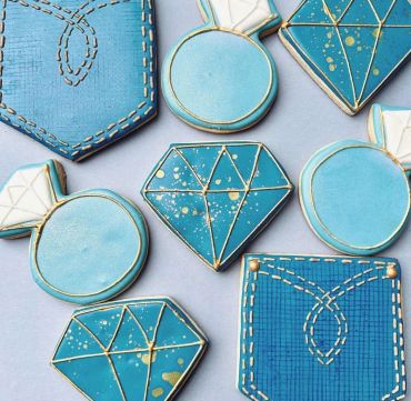 Blue and gold diamond and ring shaped decorated cookies.
