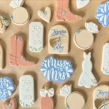 Decorative wedding-themed cookies with rings, boots, and "Miss to Mrs" text.