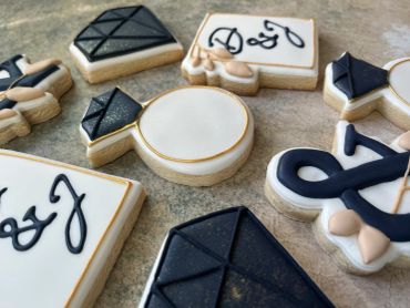 Elegant black and white decorated cookies with initials and geometric designs.