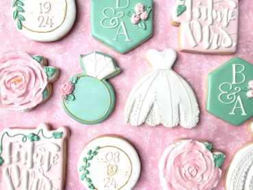 Decorative wedding-themed cookies in pastel pink, white, and mint green.