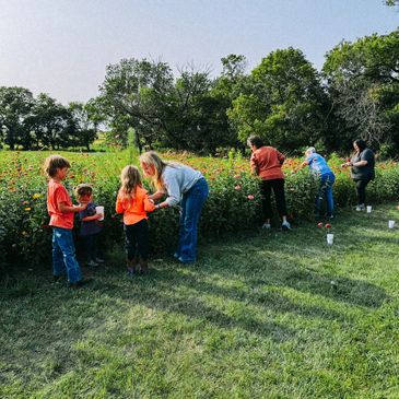 A group of people standing around in the grass.