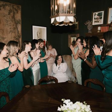 Bridesmaids clap in celebration of the bride on her wedding day