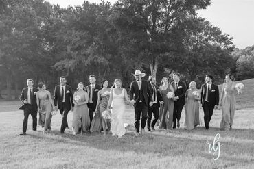 Wedding party walking towards photographer with bride and groom