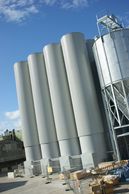 Tall industrial silos under a blue sky.
