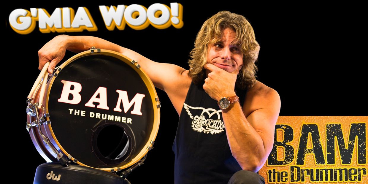 Muscular drummer posing with drum and drumsticks under 'G'Mia Woo!' text.