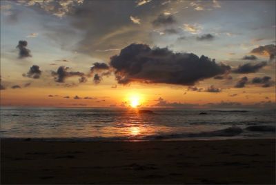 Sunset over the ocean with clouds.