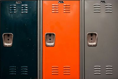 Three different colored school lockers in a row.