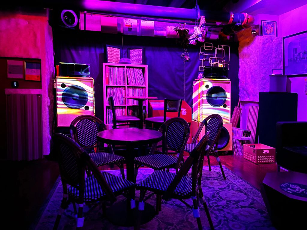 A cozy room with vinyl records and colorful lighting.