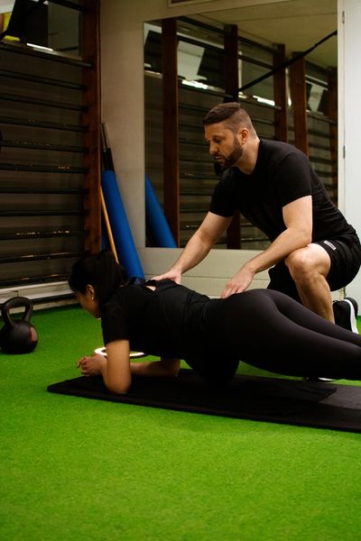 The best Fitness Trainer in Barcelona showing proper technique to his client
