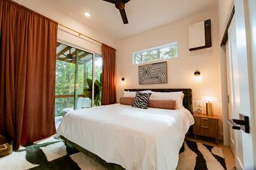 Modern bedroom with zebra print decor and large window.