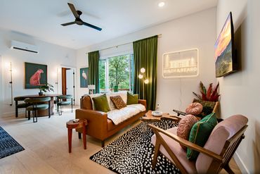 Bright modern living room with stylish furniture and green accents.
