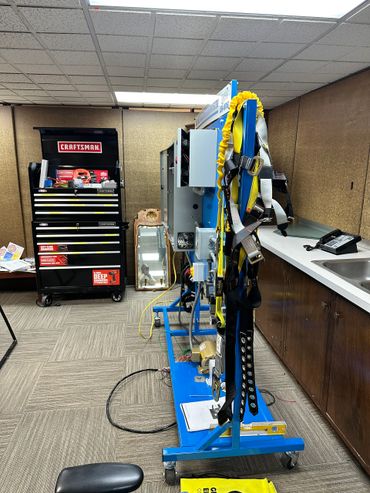 A lab setup with equipment, a tool chest, and safety harnesses.