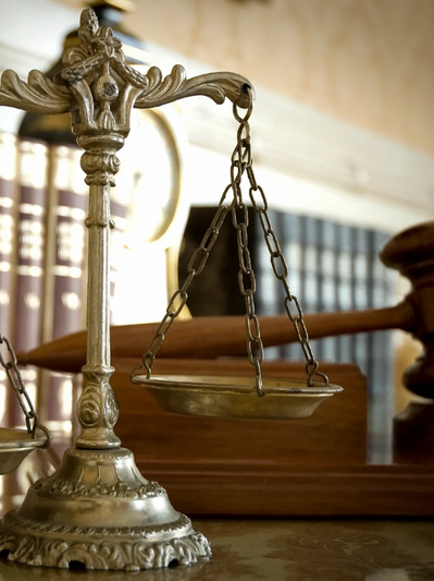 Close-up of a vintage balance scale and a gavel symbolizing justice.