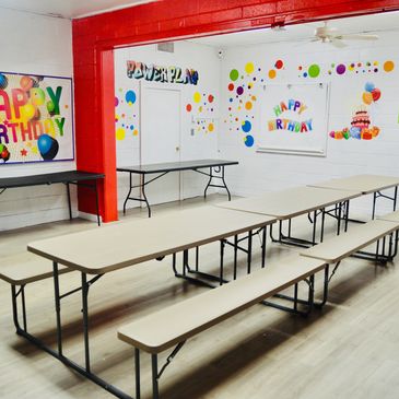 Empty party room with tables and birthday decorations.