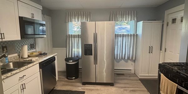 Modern kitchen with stainless steel appliances and white cabinets.