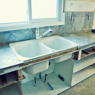 Old kitchen sink without cabinet doors.