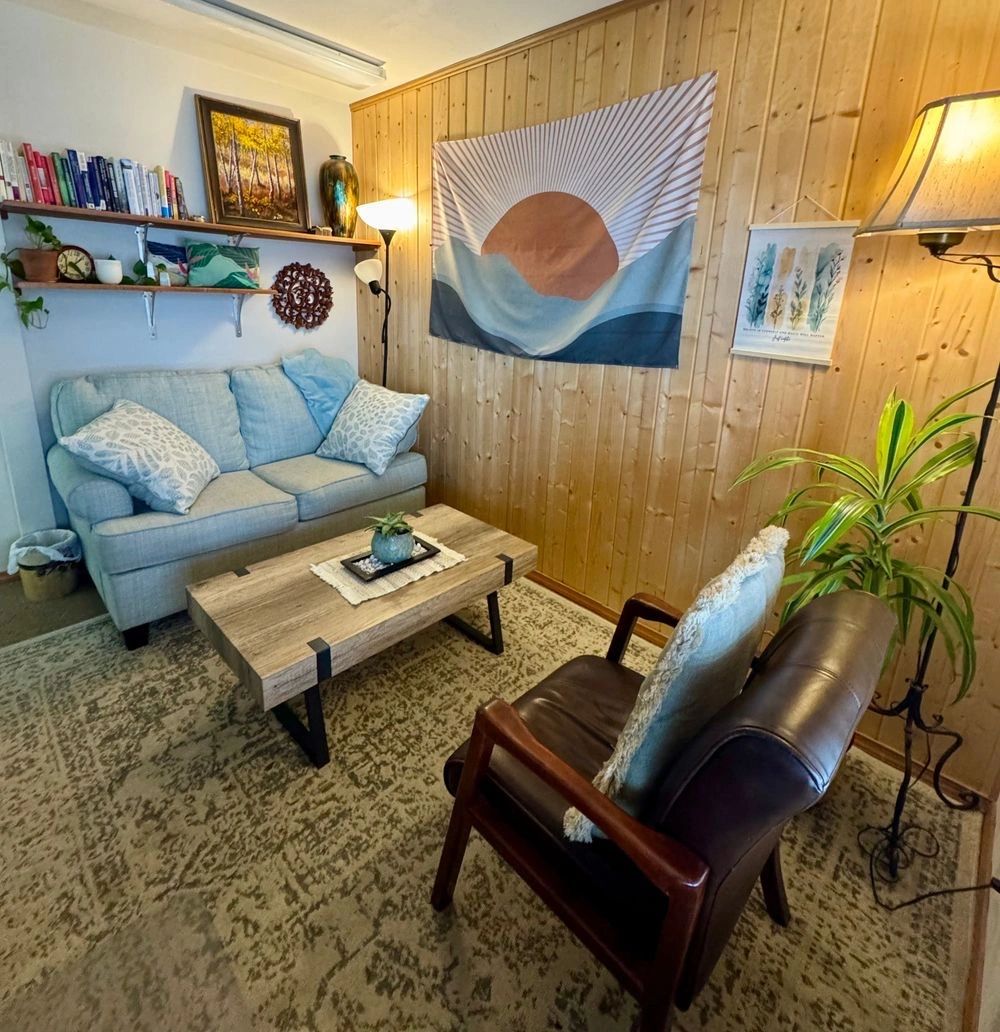 Cozy living room with light blue couch, wooden coffee table, and warm lighting.
