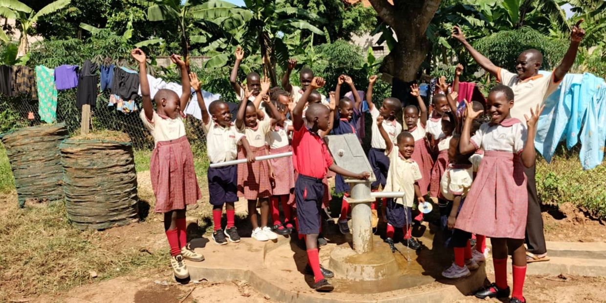 a group of students celebrating a new fresh water well