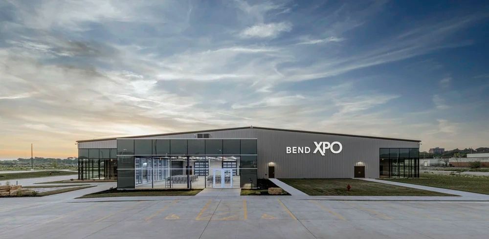 Modern Bend XPO event center with glass facade at dusk.