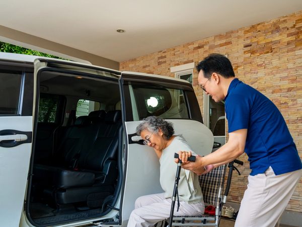 A person securing a wheelchair inside a van.