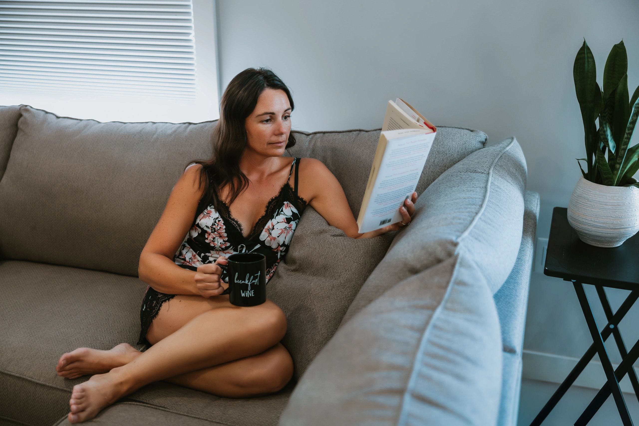 Annette Bruneau relaxing with a hot coffee or tea, reading a book.