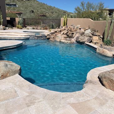 Remodeled pool with new interior pebble, tile and travertine pool decking