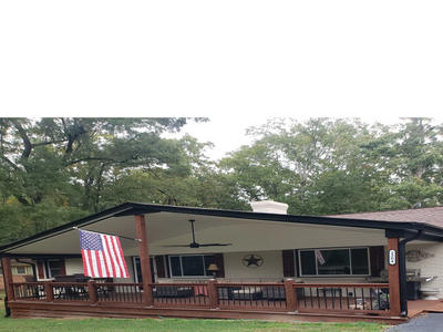A cozy porch with wooden railings and an American flag.