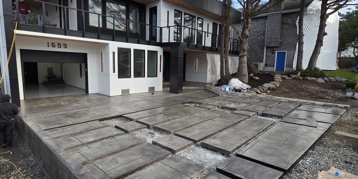 Modern house with a large concrete patio under construction.