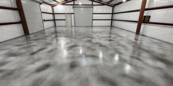 Empty industrial warehouse with polished concrete floor and metal walls.