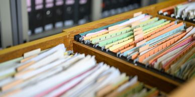 Organized file folders in a wooden drawer.