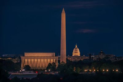 Night view of Washington DC landmarks including the Washington Monument and Lincoln Memorial.