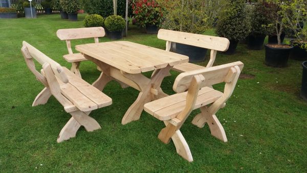 Wooden outdoor table and benches on grass.