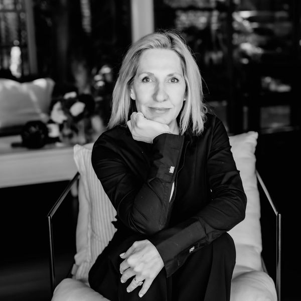 Black and white portrait of a woman sitting indoors.