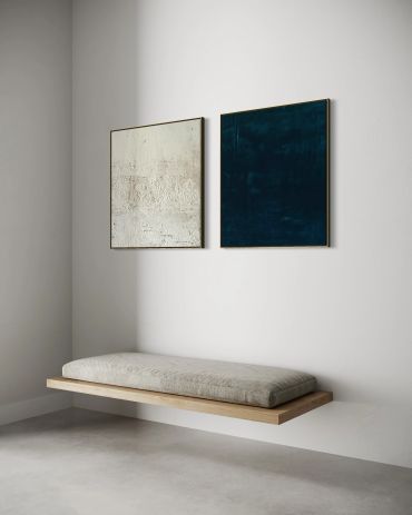 Minimalist floating bench with cushion and two abstract paintings.