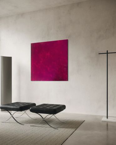Minimalist room with black stools and red artwork.