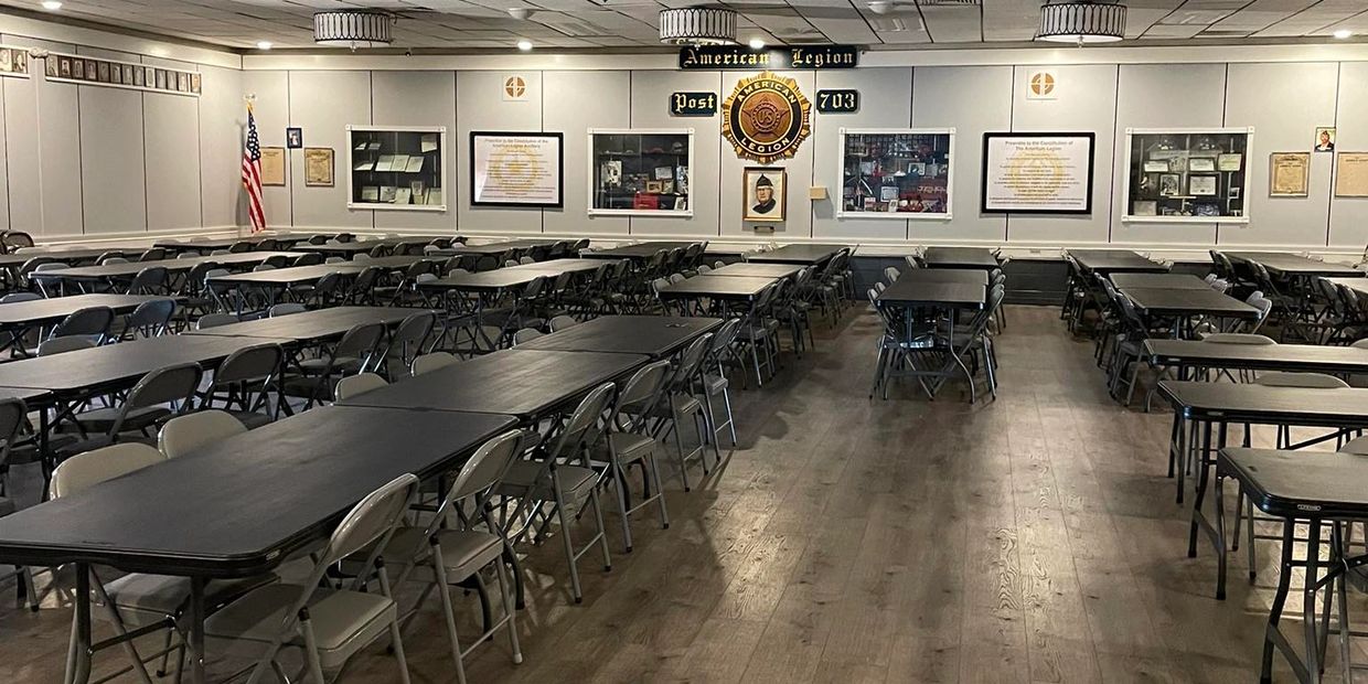 Empty American Legion hall with rows of tables and chairs.