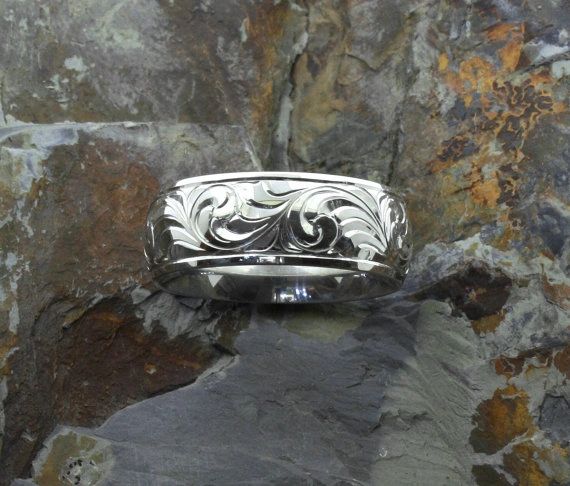 Background is a stone tile, wedding band is sterling silver with hand engraved scroll design 