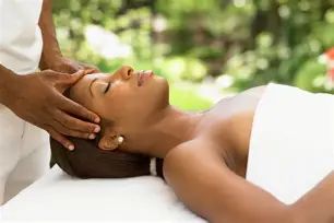 Woman receiving a relaxing head massage outdoors.