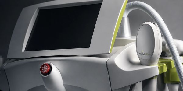 Close-up of a Venus Versa aesthetic treatment machine with control screen and handpiece.