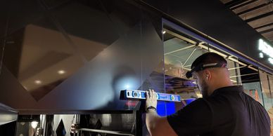Man using a level tool to check alignment on a black surface.