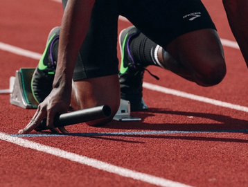 Atleta de alto rendimiento iniciando una carrera
