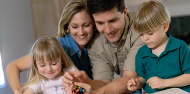 A happy family playing a game together at home.