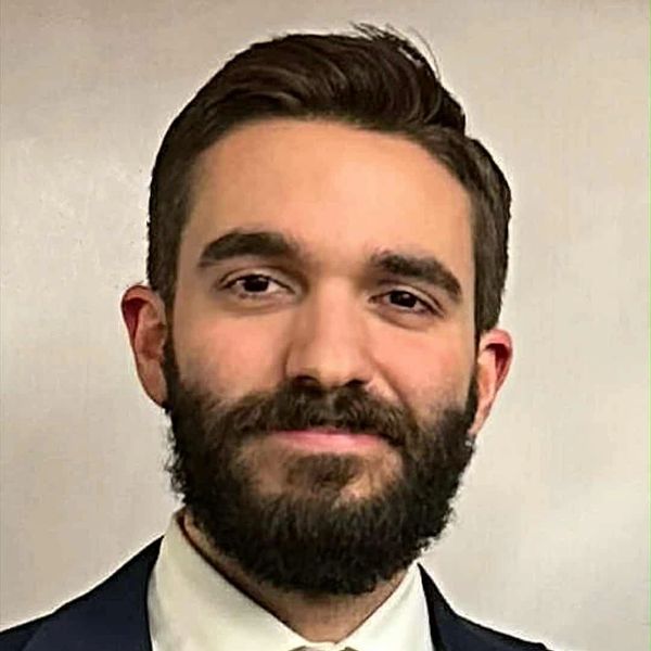 Portrait of a bearded man in formal attire with a slight smile.