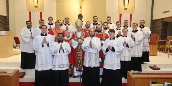 Group of clergy members posing inside a church altar area.