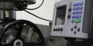 Close-up of industrial control equipment and valve wheel.